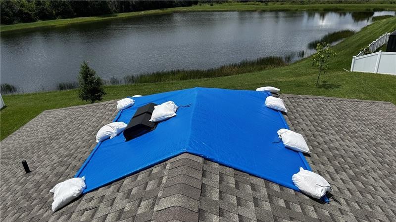 Blue tarp secured with sandbags on roof