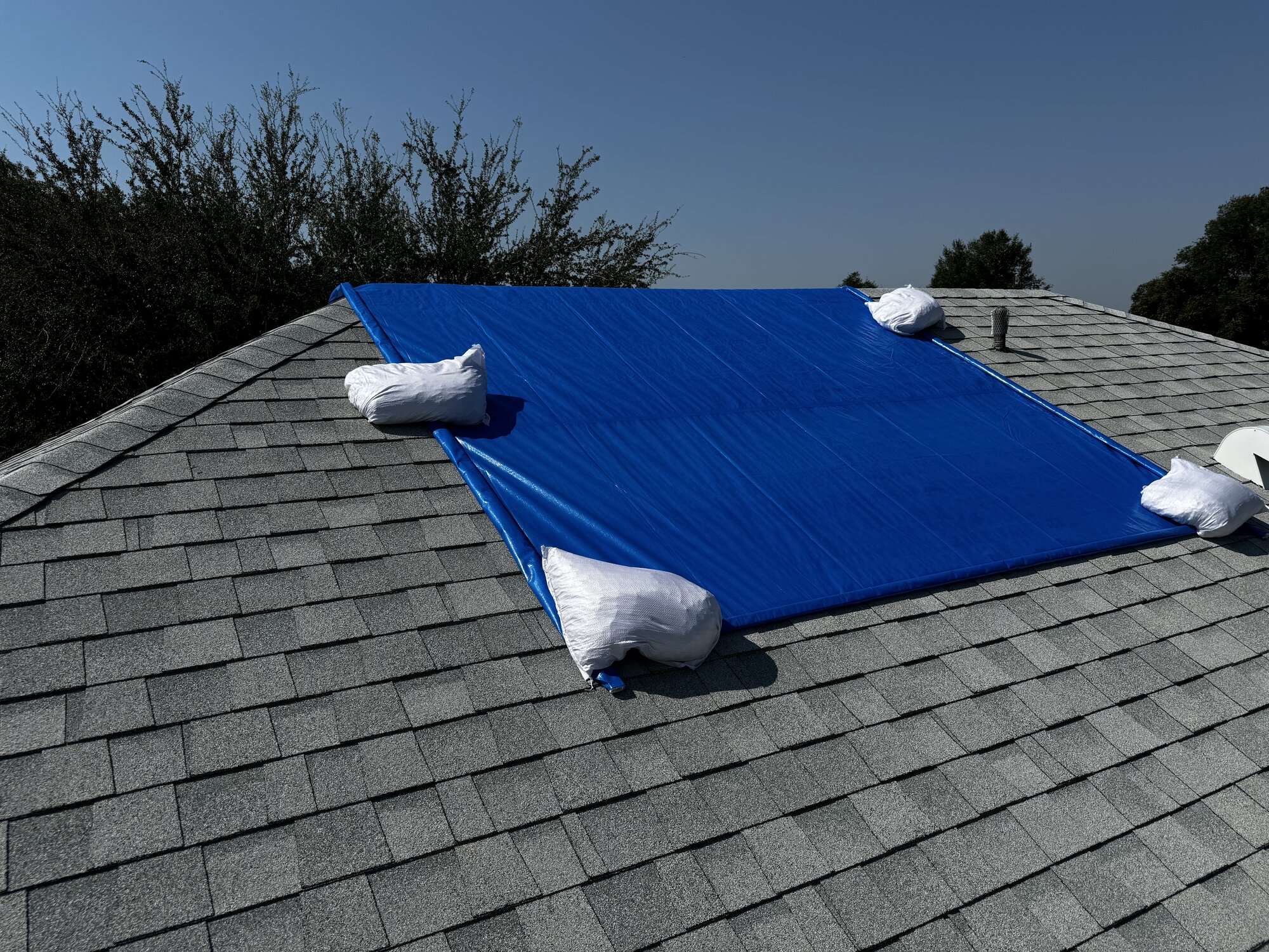 Emergency roof protection - non-penetrating sandbag secured tarp installation